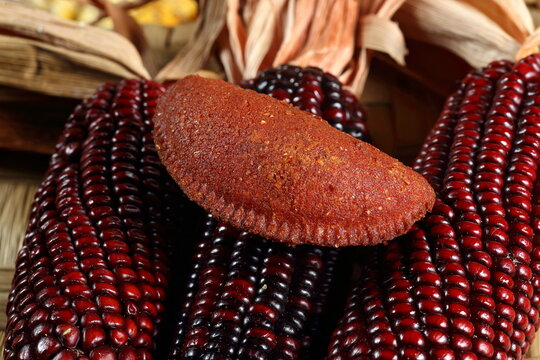 Cornmeal mush pastry served on ears of corn of various colors.