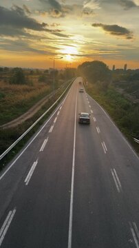 Rural Road at Sunset: Vehicles Driving on Scenic Highway Aerial