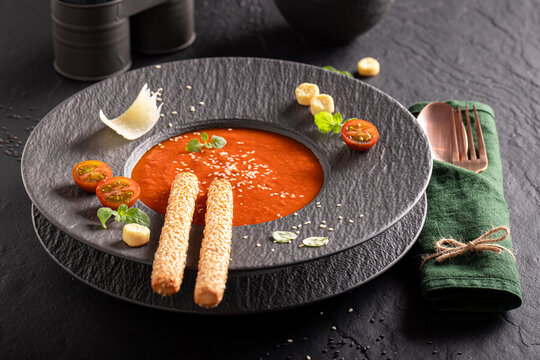 Exclusive and aromatic tomato soup decorated with crostini and spices.