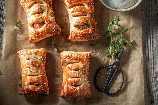 Homemade sausage in puff pastry with tatar sauce and herbs.
