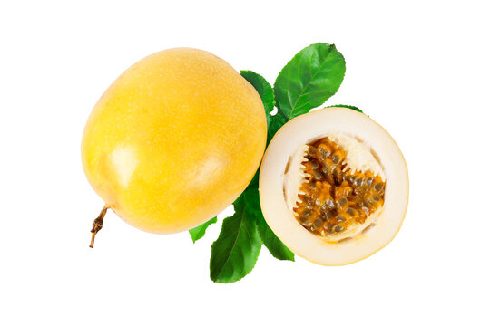Whole yellow passion fruit with sliced half revealing aromatic pulp and seeds, complemented by fresh green leaves and isolated on a white background