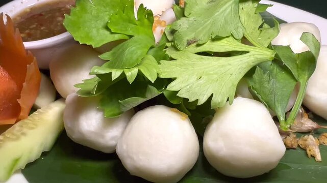 Thai Fish Balls with Fresh Herbs and Spicy Dipping Sauce Close Up, Authentic Street Food