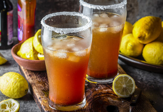Mexican beer drink Michelada. Latin American spicy refreshing beer drink with lemon juice, salt, ice tabasco and english worcestershire sauce.
