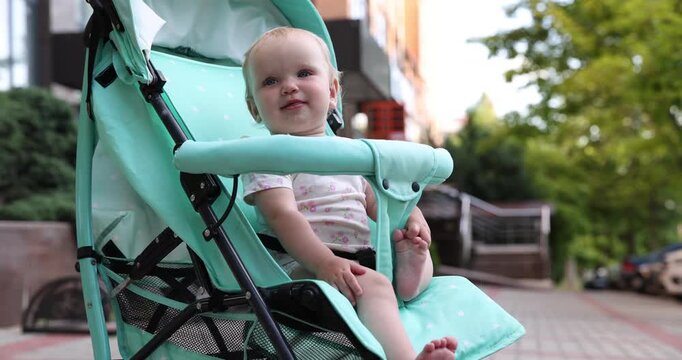 Baby carriage. Cute child in stroller outdoors, camera moving in
