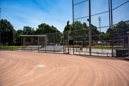 Empty baseball diamond with backstop and bleachers.