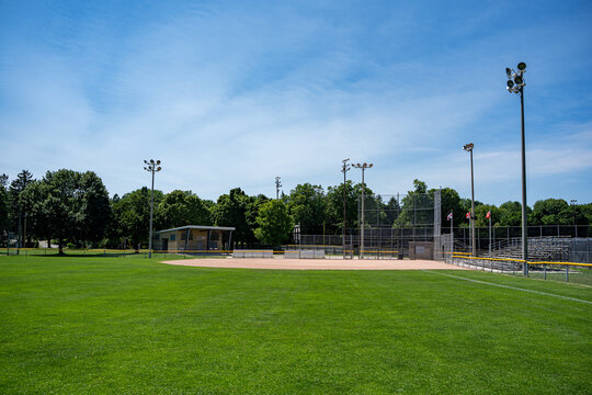 Empty community baseball field under blue sky.