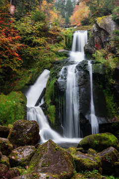 Triberg Waterfalls flowing through Black Forest autumn landscape