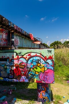 Colorful graffiti covered railroad bridge with lone chair on tracks