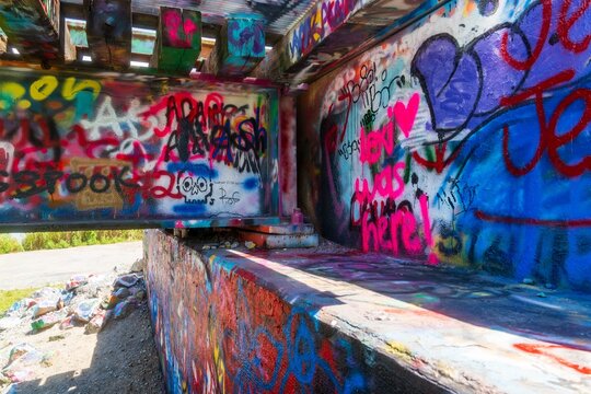 Colorful graffiti covered concrete bridge underpass with tags and hear