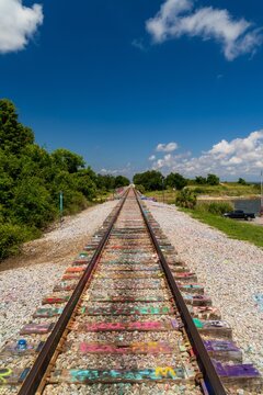 Colorful graffiti painted railroad track ties leading to horizon