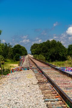 Graffiti-covered railroad tracks crossing a rural bridge