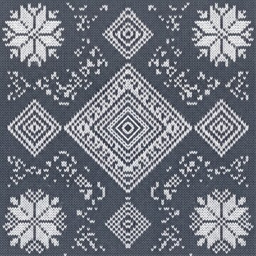 Seamless gray knitted pattern with white snowflakes and diamond shapes for winter clothing.