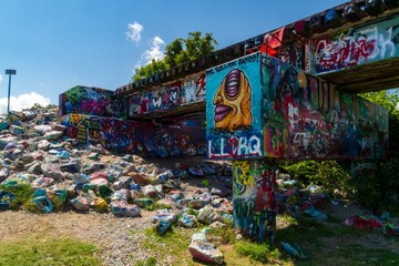 Colorful graffiti-covered bridge and painted rocks in Austin © Robert