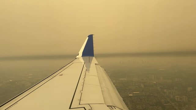 Toronto, Ontario, Canada - July 15, 2026 - Aircraft wing enveloped in thick wildfire smoke haze during approach over Toronto Pearson during wildfire smoke emergency