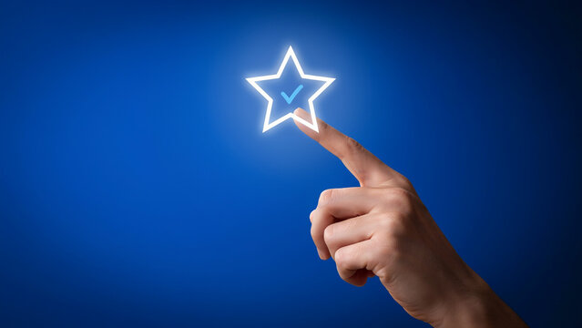 Glowing star with checkmark being touched by a human hand blue background