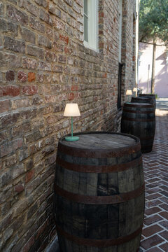 Wine barrels with lamps along historic brick alley walkway