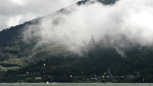 kitesurfing at lake calima under cloudy mountain scenery