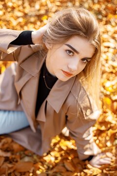 Portrait of a young woman posing for a photo in autumn park