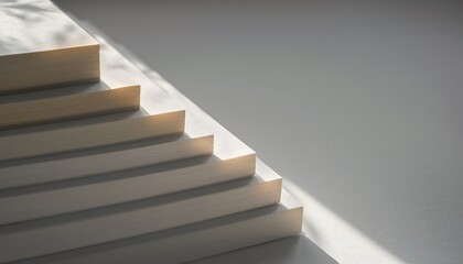 Naklejka premium Stack of blank hardcover books on minimalist white shelf with soft natural lighting