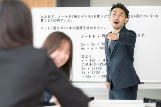 授業中におしゃべりの私語をして教師に注意される女子高校生　学校教育と教室での指導風景　内申点、生徒指導のメージ