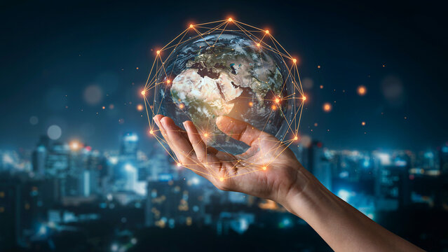 Global network connection concept with digital earth globe held in hand over blurred night city background symbolizing technology and communication