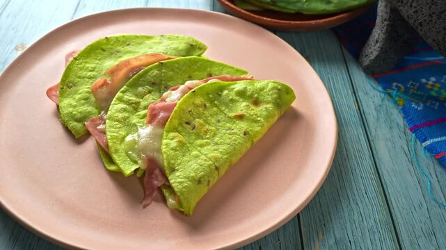 Aerial view of nutritious green quesadillas with nopal flatbread, ham, and melted cheese