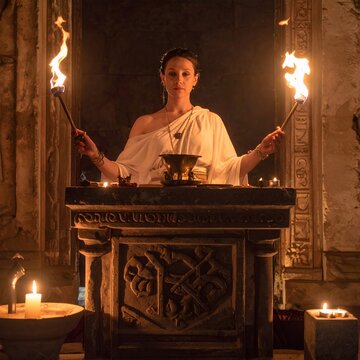 Ancient Priestess Holding Torches in Ritualistic Ceremony.