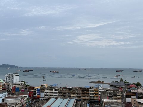 Si Racha harbor with boats and coastal cityscape in Thailand