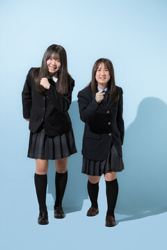 水色背景で未来や将来へ向かって走る、歩く日本人女子高生や中学生　2人で前向きにスタートする受験や青春、合格やオープンキャンパスイメージ全身の正面