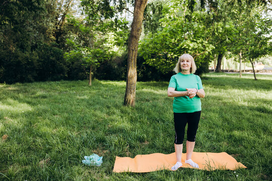 Senior woman doing yoga exercise in park