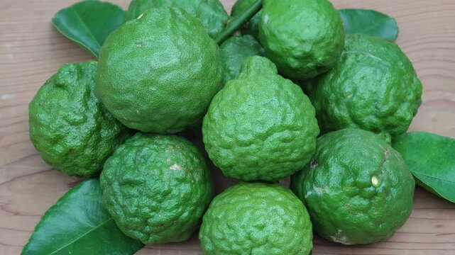 Fresh Makrut Limes on Rustic Wooden Board