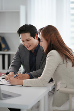 Supervisor guiding mentor training new trainee in office environment with learning focus and clarity