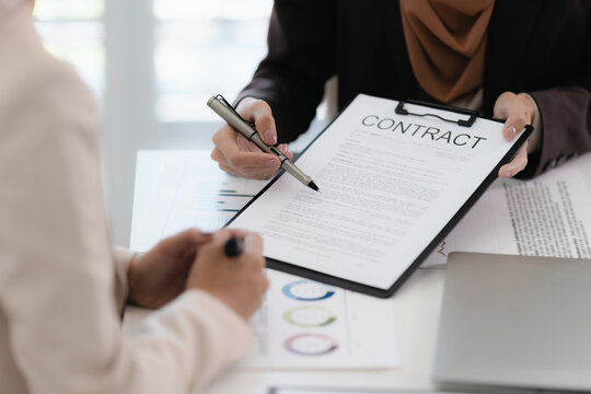 Corporate analyst sitting at desk with audit papers, financial ledger and calculator in business environment