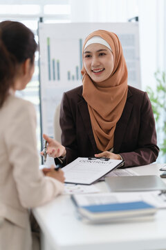 Two diverse colleagues discussing in conference room