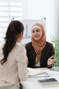 Two diverse colleagues discussing in conference room