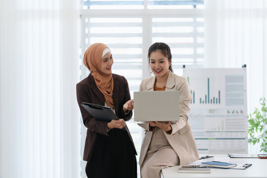 Two diverse colleagues discussing in conference room