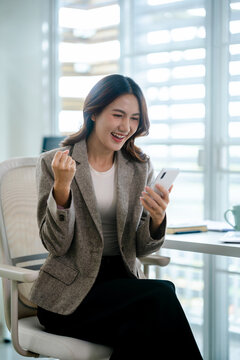 excited busineswoman watching on mobile phone read a good news