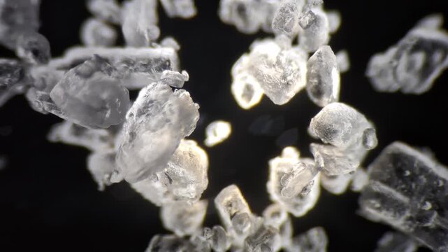 Microscopic view of table salt crystals with focus pull on black background, macro. 