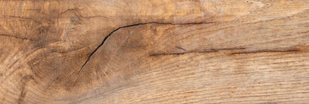 Natural brown weathered wooden plank texture with knot and dark cracks background