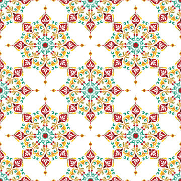 seamless floral pattern. A traditional seamless textile pattern featuring intricate red and green ethnic floral mandala motifs on white.