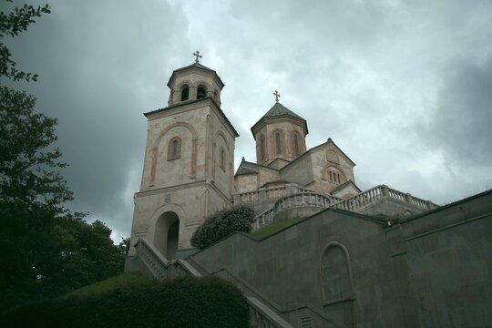 Historical Bodbe monastery complex under dramatic storm sky in Georgia