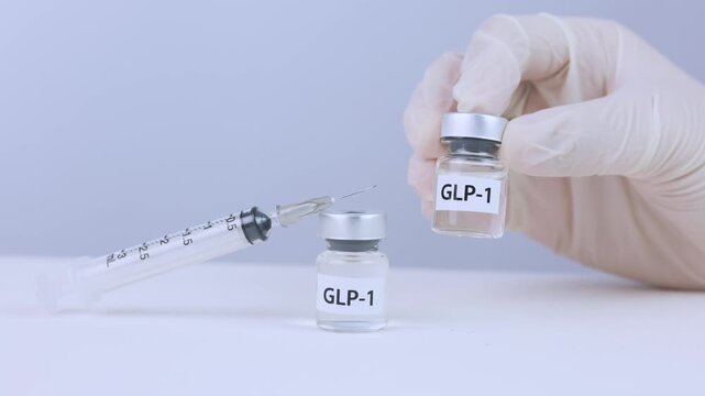 Professional gloved hand holding medical GLP 1 hormone vial near sterile syringe during successful clinical weight management therapy preparation