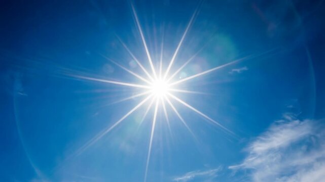 Bright sun shining in clear blue sky with soft white clouds on a sunny day