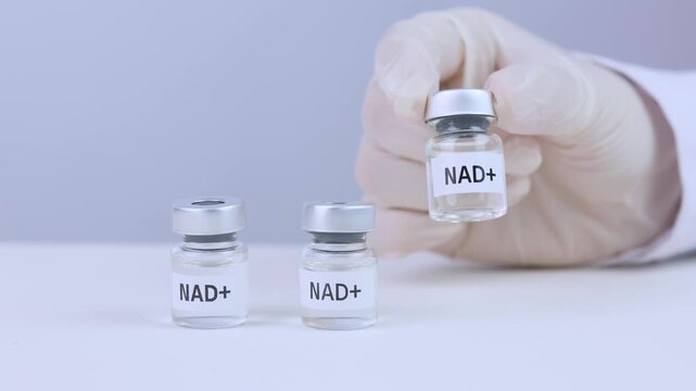 Clinical hand with white glove holding nad therapy medicine vial carefully shows hope for modern science health longevity treatment in laboratory