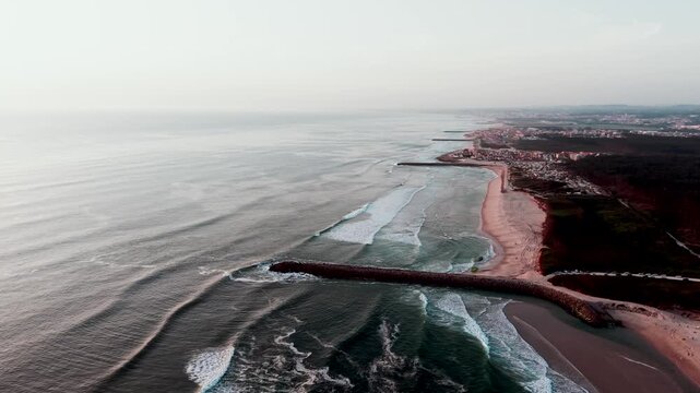 Waves break beside stone jetty leading into bay at Sao Pedro de Maceda in Ovar Portugal