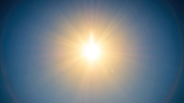 Low angle timelapse sun on blue sky concept. Bright sun radiating warmth in a clear blue sky backdrop.