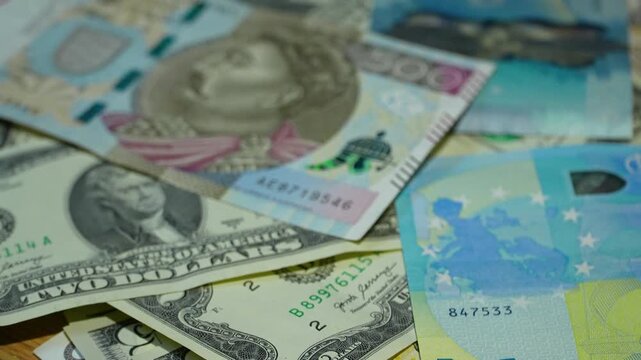 A diverse collection of international paper money including US dollars, Euros, and Polish Zloty. Cinematic close up of global finance and economy concepts.