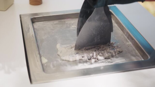 Ice cream maker hand-making Oreo Ice Cream with black gloves, close up shot, handheld