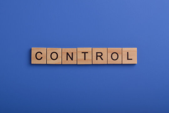 Wooden letter blocks spelling control on a blue background, representing management, authority, regulation, governance, compliance, security, organization, and business concepts.
