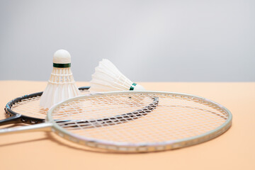 Badminton Rackets and Shuttlecocks on Peach Background